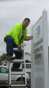 Man installing new library sign