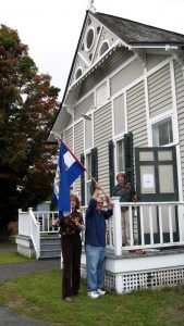 People taking down open flag for last time at old library building
