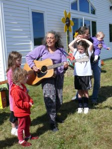Woman playing guitar for children